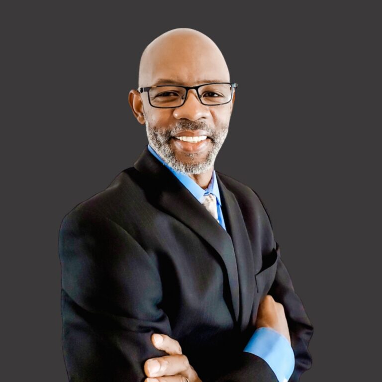 Antwaun Coach T Thompson in a dark suit, smiling, arms crossed